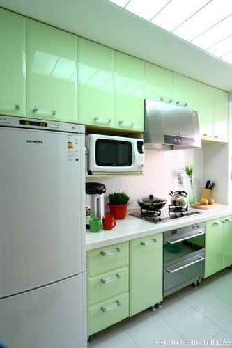 清新淡绿色的橱柜、透光的顶面把阳光引入室内，厨房成了一道亮丽的风景