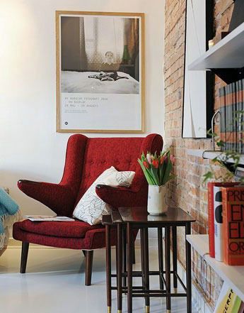 一把点睛的红色休闲沙发营造出这个角落的时尚活力感，一个可伸缩的边几平时用来放置些盆栽以作点缀空间之用，需要时可以伸展成为放书写字的案桌
