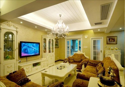 客厅内米色墙壁与杏黄色沙发和谐搭配，晶莹剔透的水晶吊灯华丽璀璨，将整个大厅映衬得通透明亮