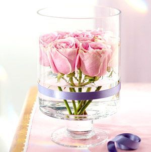 选一个透明的玻璃杯剪下几株含苞欲放的粉红玫瑰放在盛有水杯子里