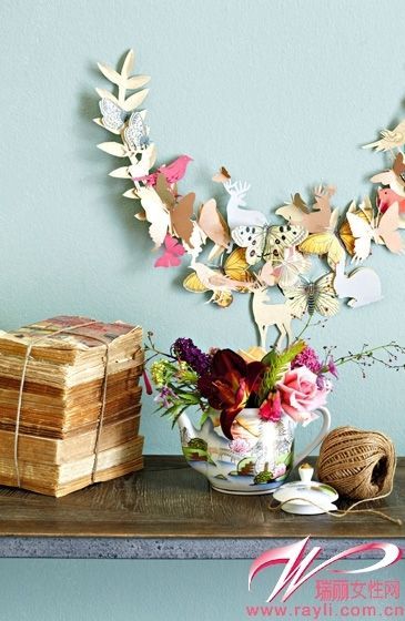 墙上的装饰是用礼品包装纸剪的各种可爱图案串制而成的