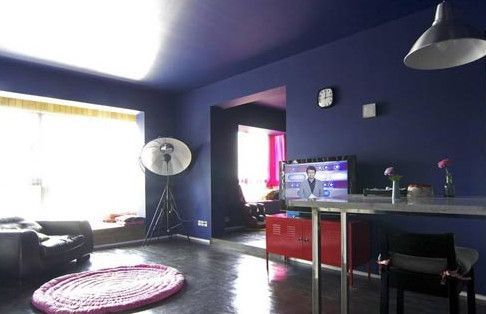 客厅整体为深蓝色，为了不显单一用了红色电视柜粉色坐垫来做点缀