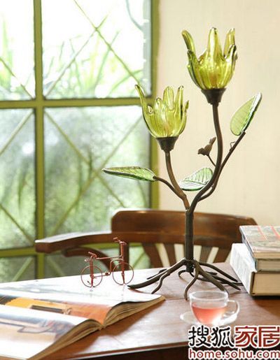 曼妙的花茎姿态取代了一成不变的台灯支架，以绿色透光玻璃灯罩作为花朵，让灯光散发出来显得更加柔美