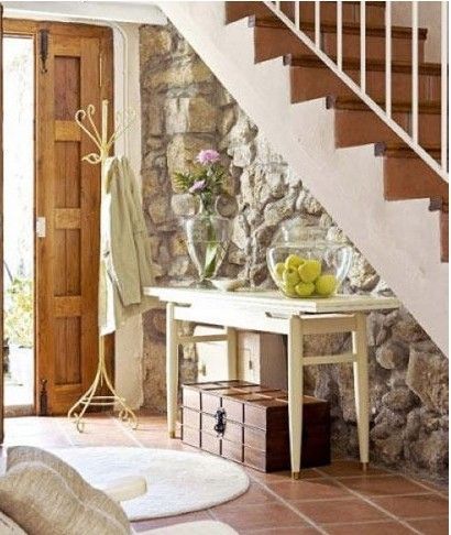 将楼梯间装修改造成玄关，是十分实用的。只要在楼梯间放上一个小桌子和一个衣帽架，楼梯间就能构成一个简单的玄关。再在桌子上放上些装修装饰物，起到美化楼梯间的效果