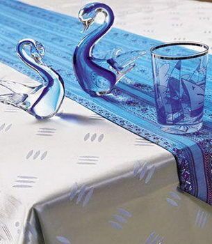 蓝色的桌祺采用刺绣工艺制成，图案和色彩的搭配具有民族风范，与下面搭配的浅淡色调防水桌布在视觉上形成反差，无形之中把桌祺烘托成了餐桌的主角