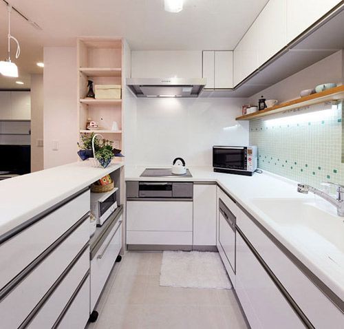 纯白色的整体橱柜，将厨房区域装饰的干净整洁。分层的整体橱柜，金属材质的装饰条，衬托出厨房的现代气息，给人耳目一新的感觉