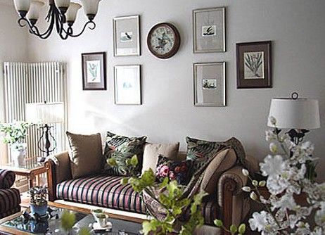 客厅区域，既带木色质朴，又有布艺柔软感的沙发，客厅的花鸟照片墙装饰